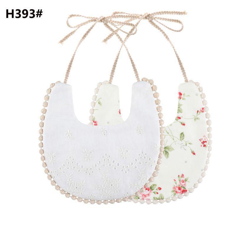 Double-sided cotton baby bib with tassel ties; white eyelet and floral print.
