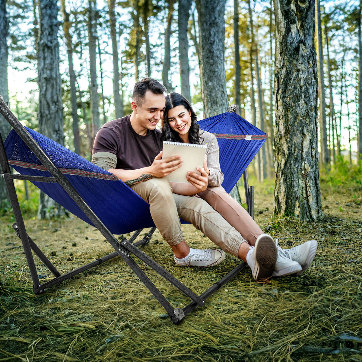 Blue hammock with medium stands, two people relaxing on stretched fabric