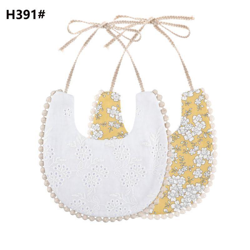 Double-sided cotton baby bib with tassel ties; white eyelet and yellow floral print.