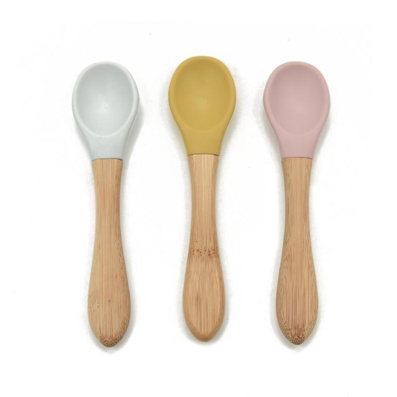 Set of 3 baby feeding spoons with wooden handles and silicone tips in gray, yellow, and pink