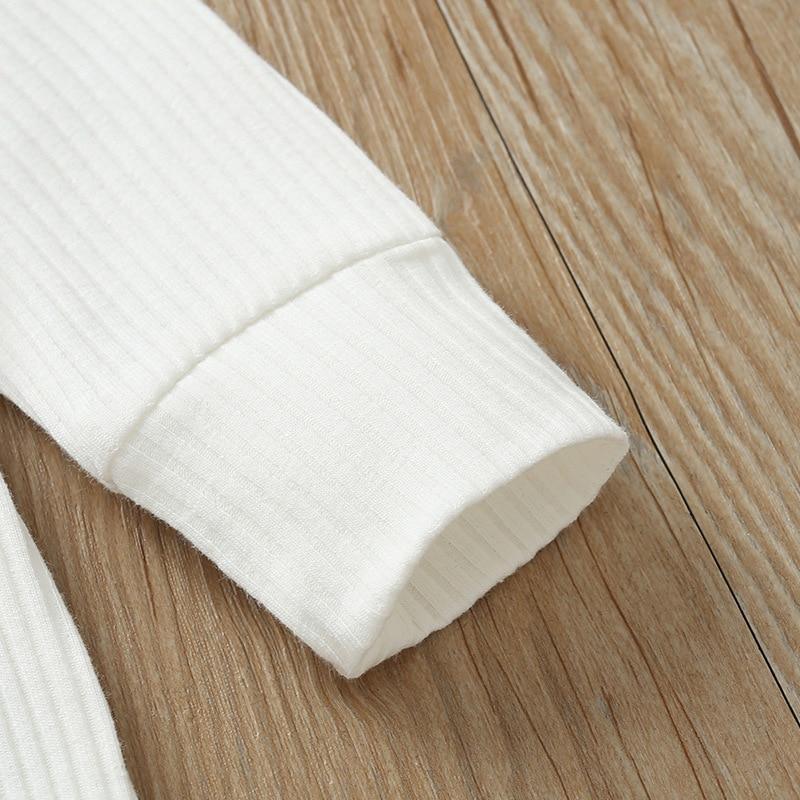 White newborn ribbed romper sleeve cuff detail on soft knit fabric