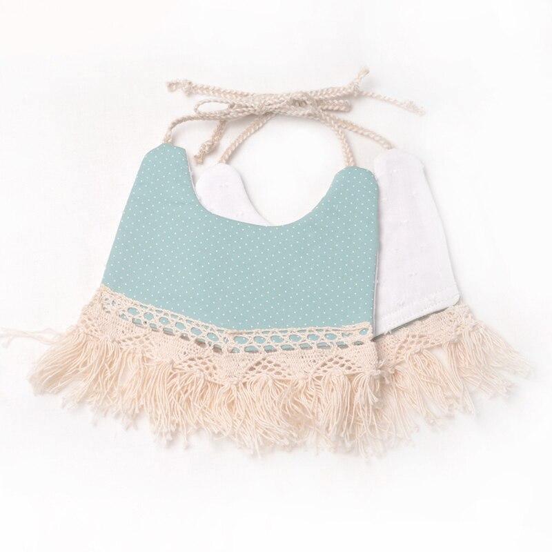 Teal dotted double-layer baby bib with white backing, tassel fringe, and pom trim ties