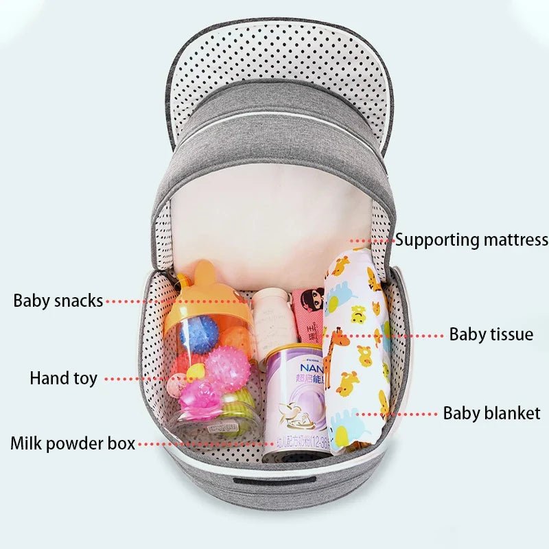 Grey baby bassinet with zip-open storage net showing toys and baby essentials