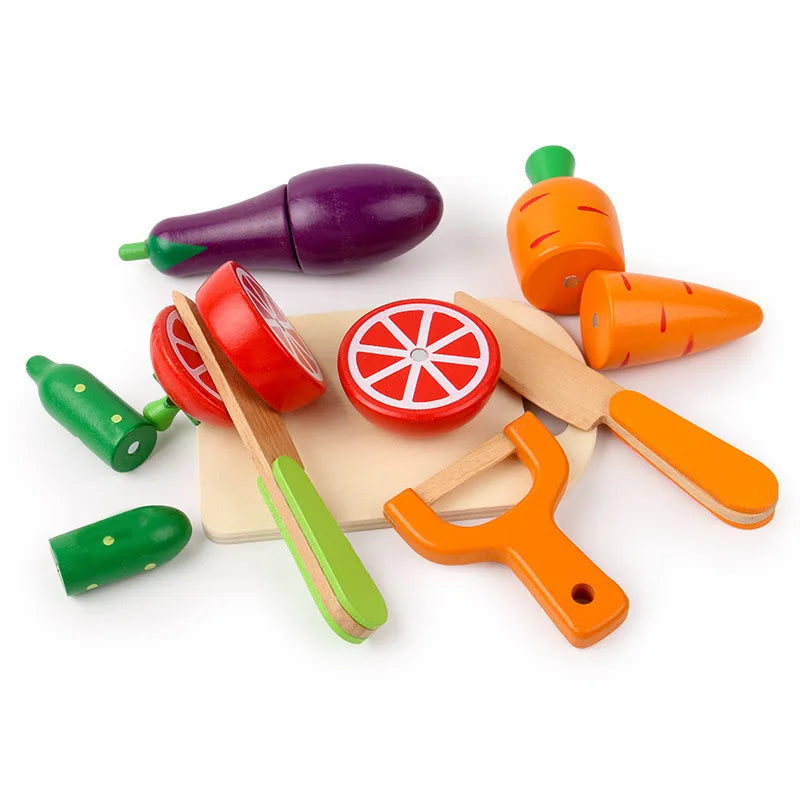 Wooden cutting board with sliced toy fruit and vegetables and a wooden knife