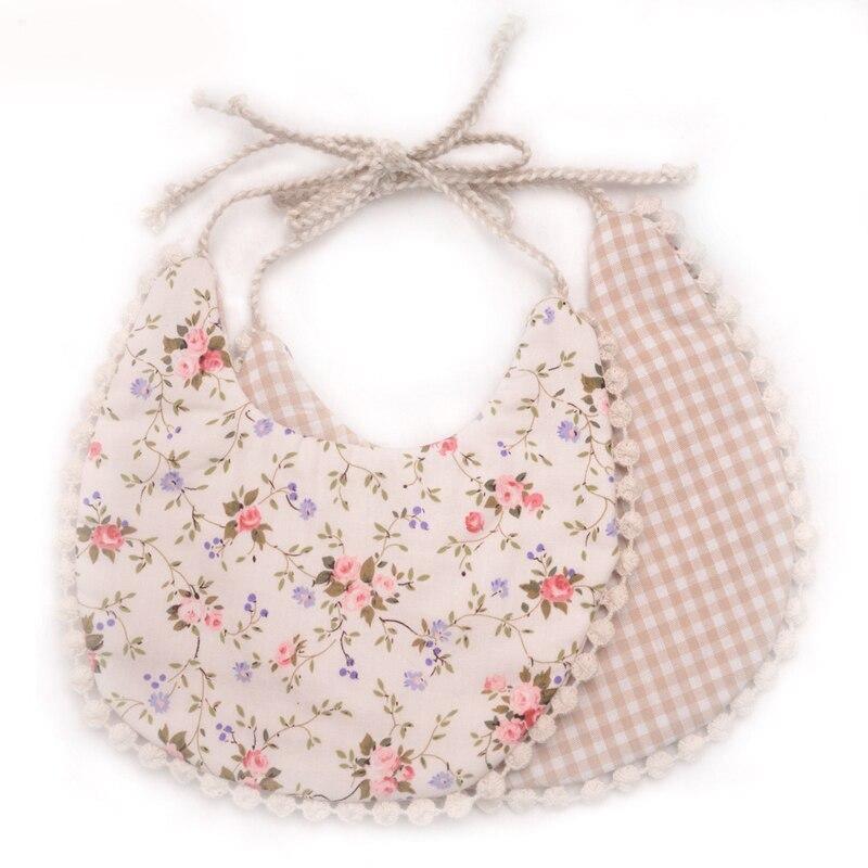 Baby bib set with floral print front and gingham plaid back, tassel ties and pom-pom trim