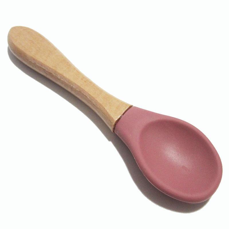 Baby feeding spoon with light wood handle and dusty rose silicone tip