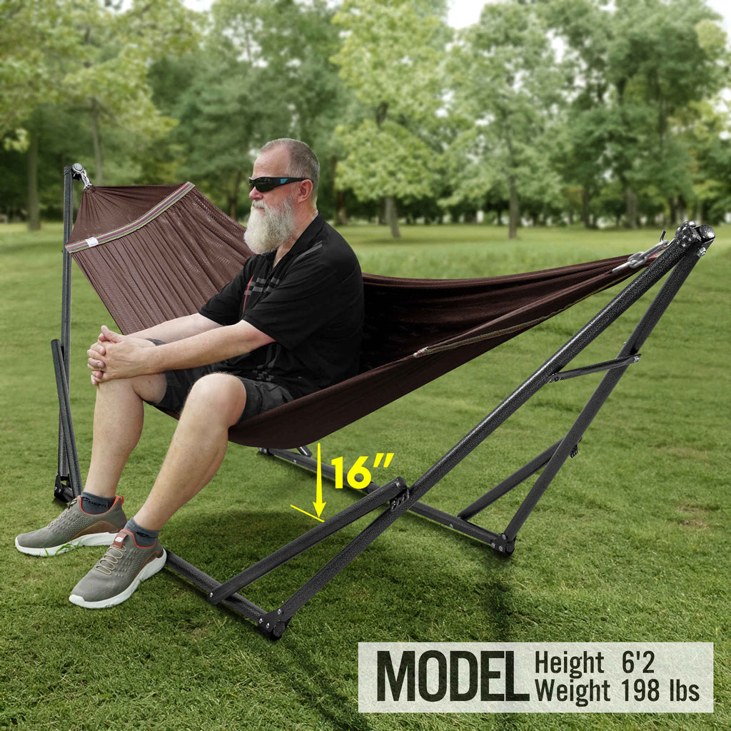 Brown hammock on black folding stand with adjustable-height bars outdoors