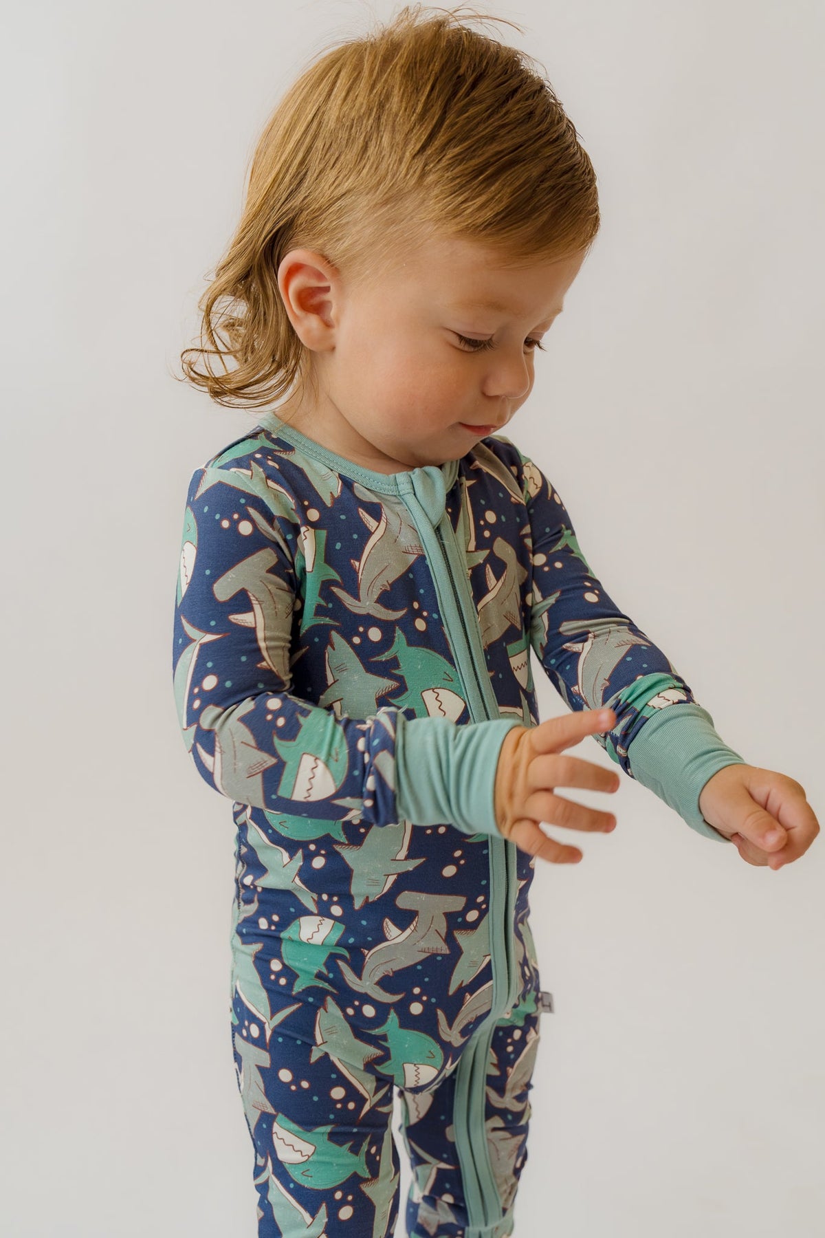 Navy and teal shark-print baby overalls with zip front and long sleeves