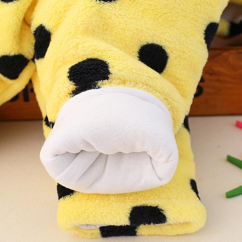 Close-up of yellow plush foot with white paw detail on bear costume romper
