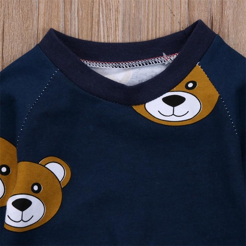 Navy long-sleeve boys pajama top with bear-face graphic at the chest