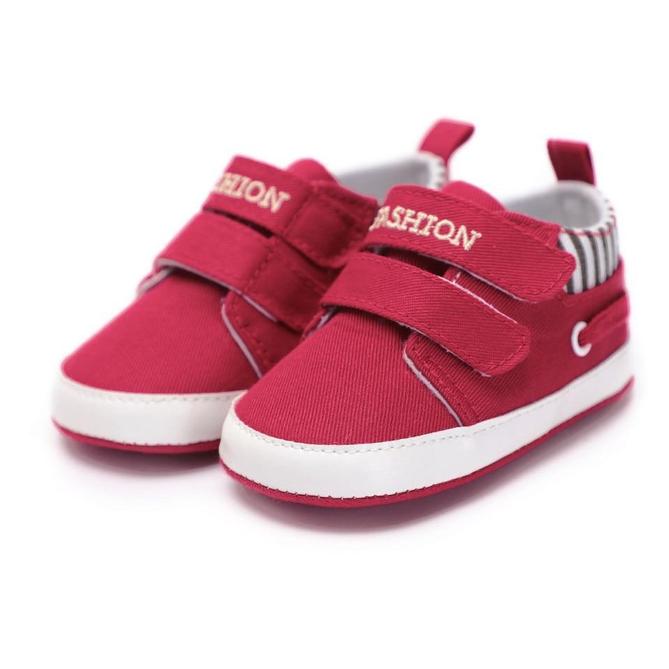 Infant canvas sneakers in red with hook-and-loop straps, white sole, and striped lining