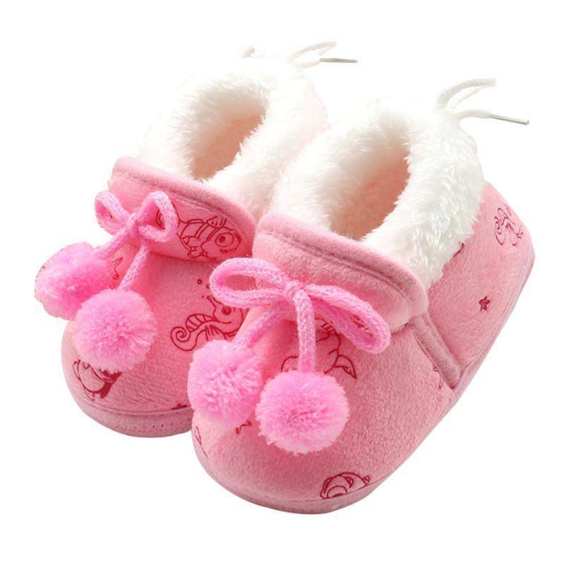 Pink baby winter boots with fuzzy white collar, ribbon laces, pom-pom trim