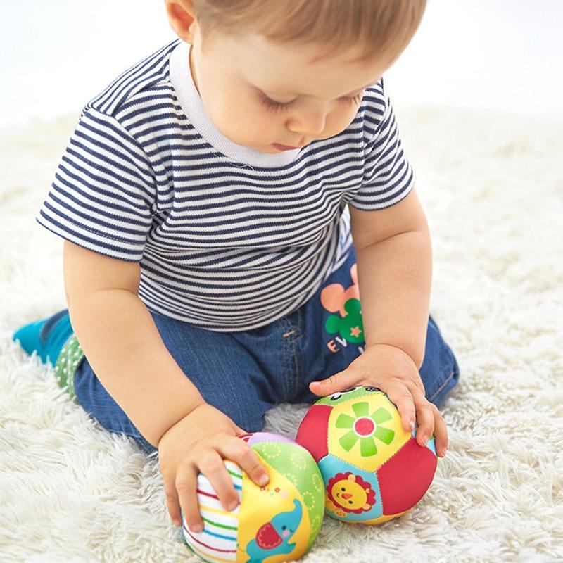 Plush animal rattle ball with colorful panels and lion and bird designs