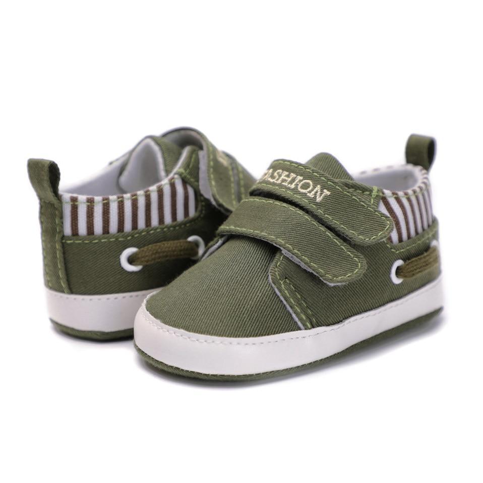 Infant canvas sneakers in olive green with hook-and-loop straps and striped collar detail
