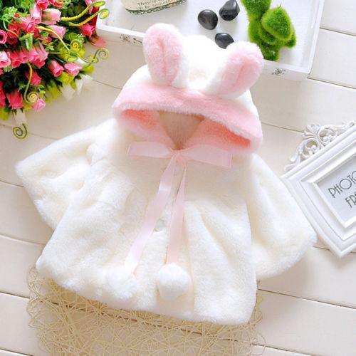 White faux-fur baby coat cloak with bunny-ear hood, pink inner trim, pom accents
