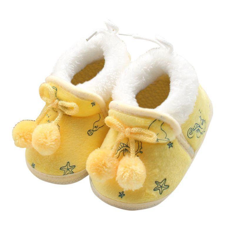 White and yellow baby winter boots with fuzzy cuffs and lace tie, pom-pom accents