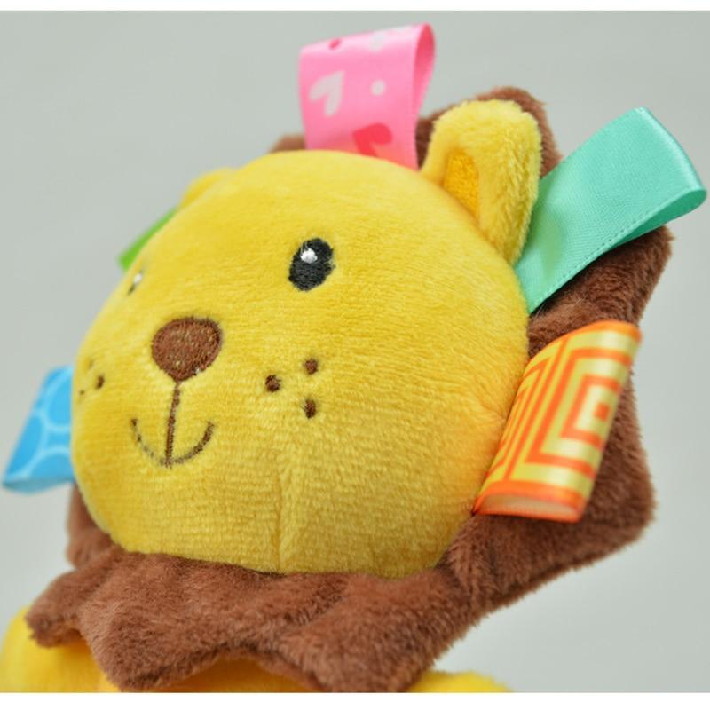 Close-up of yellow bear plush baby rattle with colorful ribbon tags and bell