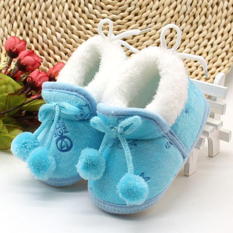 Blue and white baby winter boots with fluffy cuffs and pom-pom lace ties