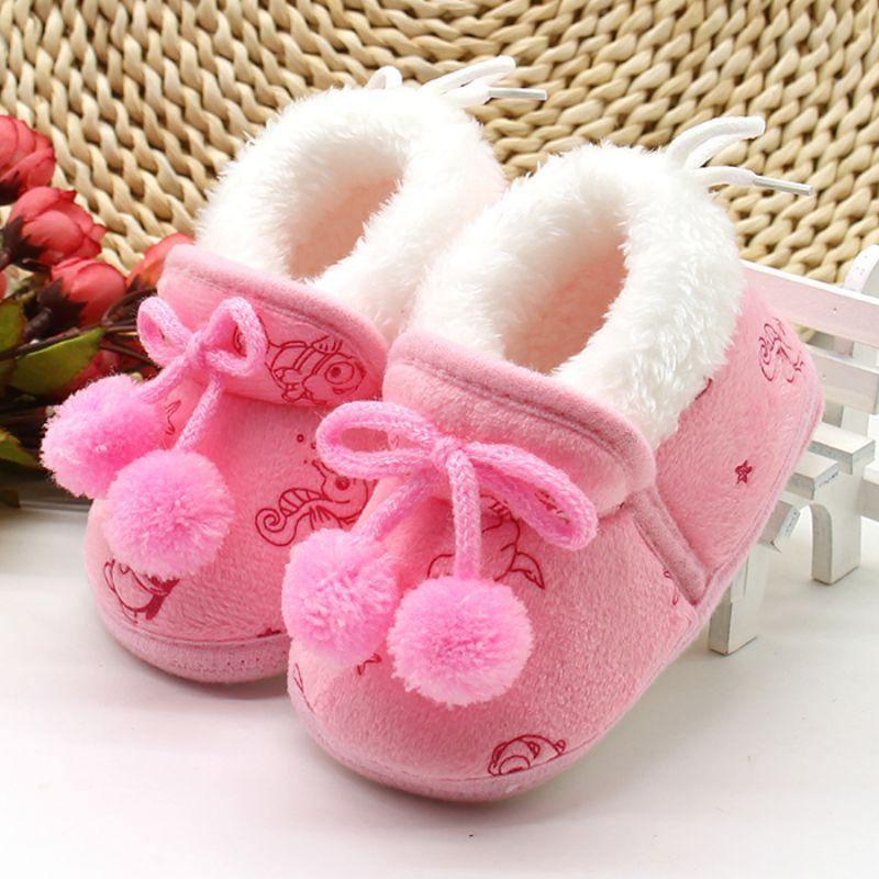 Pink baby winter boots with fuzzy white collar, ribbon laces, pom-pom trim