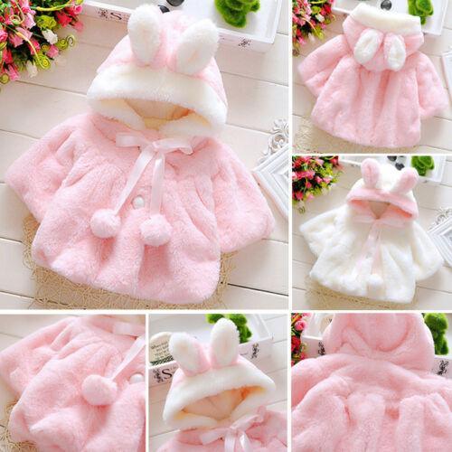 Pink faux-fur baby coat cloak with hood, bow tie, and pom accents