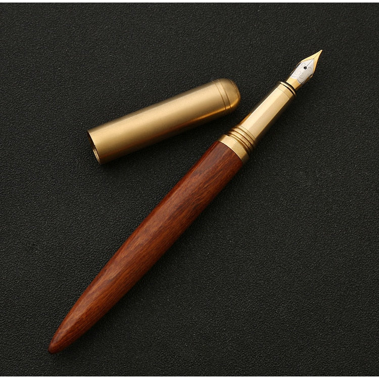 Handmade fountain pen with reddish-brown wood barrel and brass details, gold nib