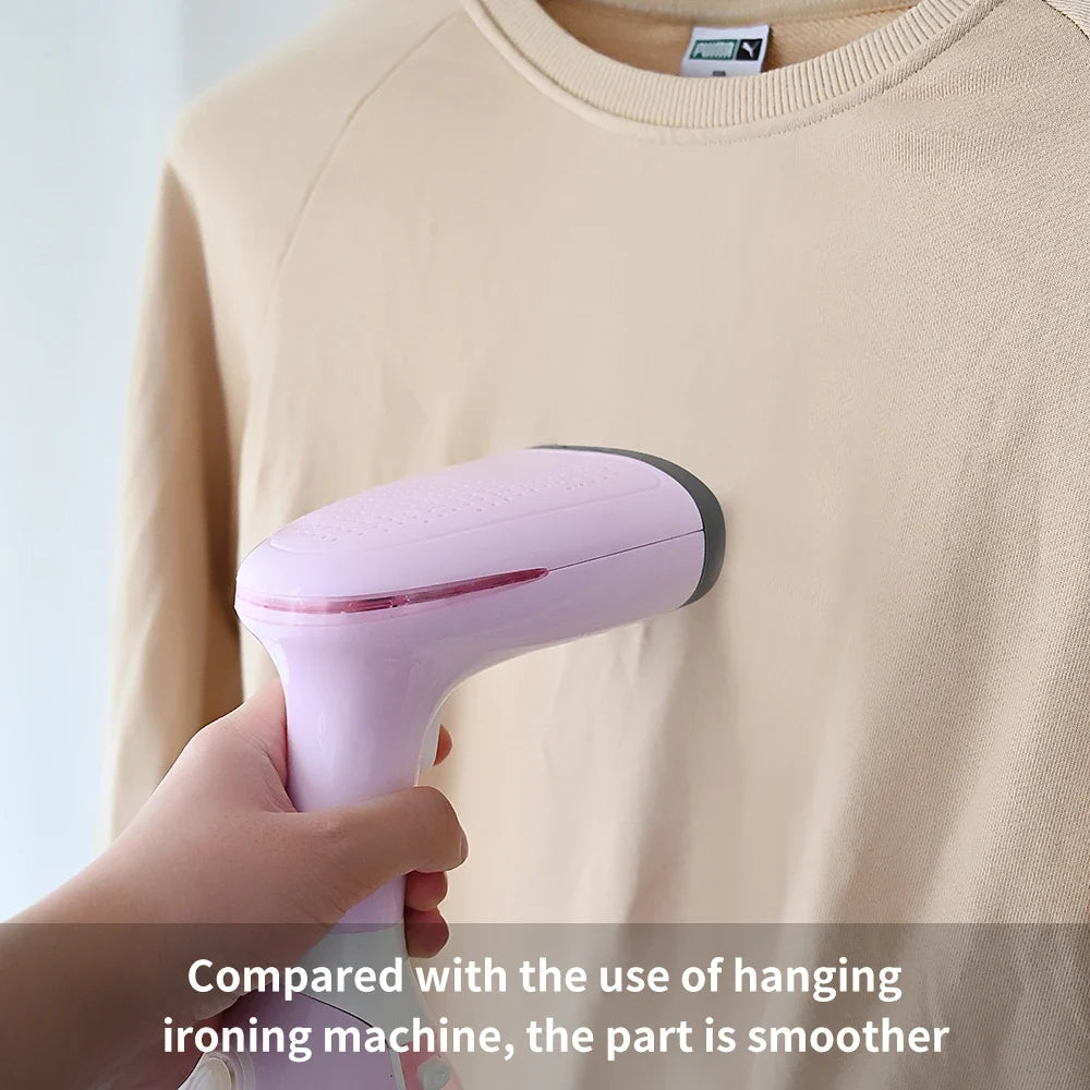 Handheld garment steamer in pink steaming a light beige sweater, handheld use