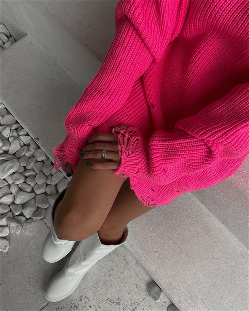 Pink oversized knitted sweater dress with round neck, long sleeves, frayed hem and cuffs