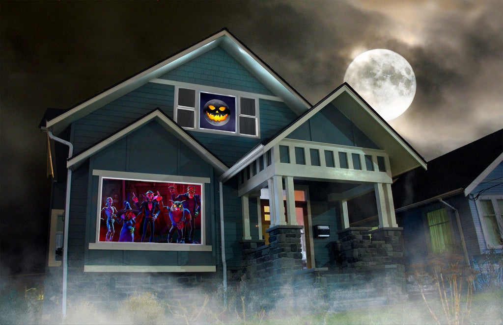 Halloween window projection showing purple monsters and a jack-o-lantern face