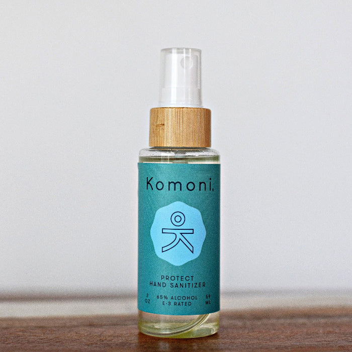 Instant hand sanitizer bottle in blue with clear spray cap and wood collar