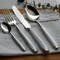 Polished stainless steel flatware set with Roman-column handles, spoons and forks