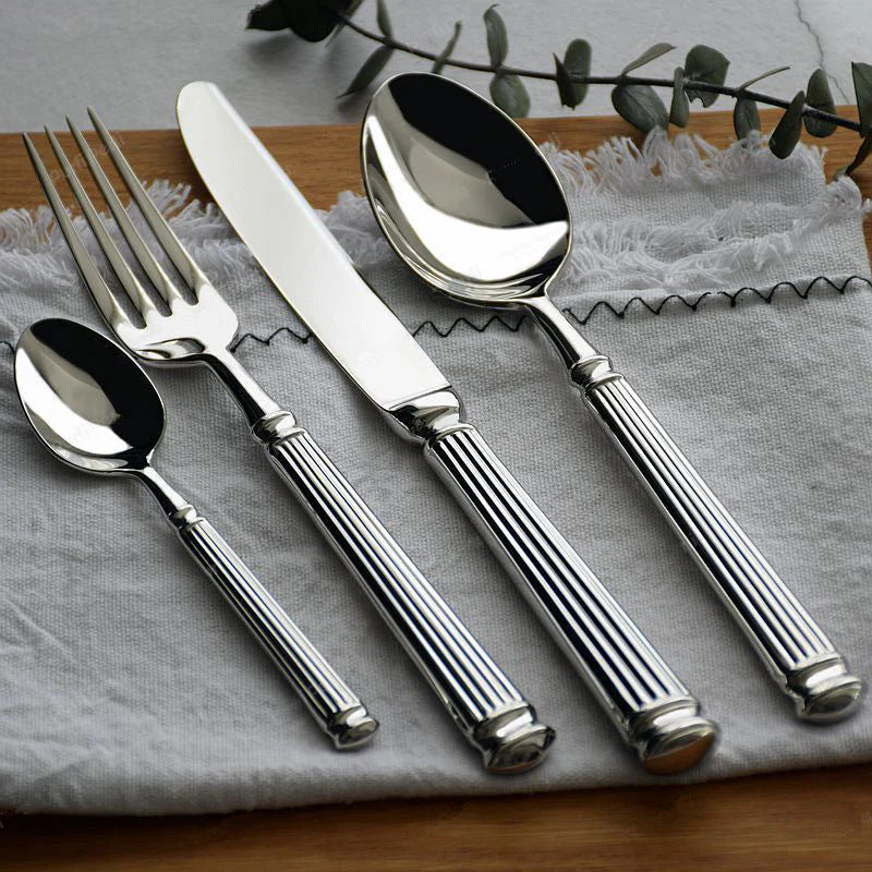 Polished stainless steel flatware set with Roman-column handles, spoons and forks