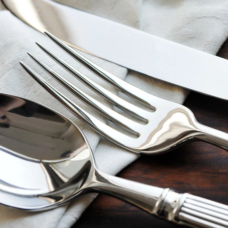 Close-up of polished stainless steel spoon and fork with Roman-column handles