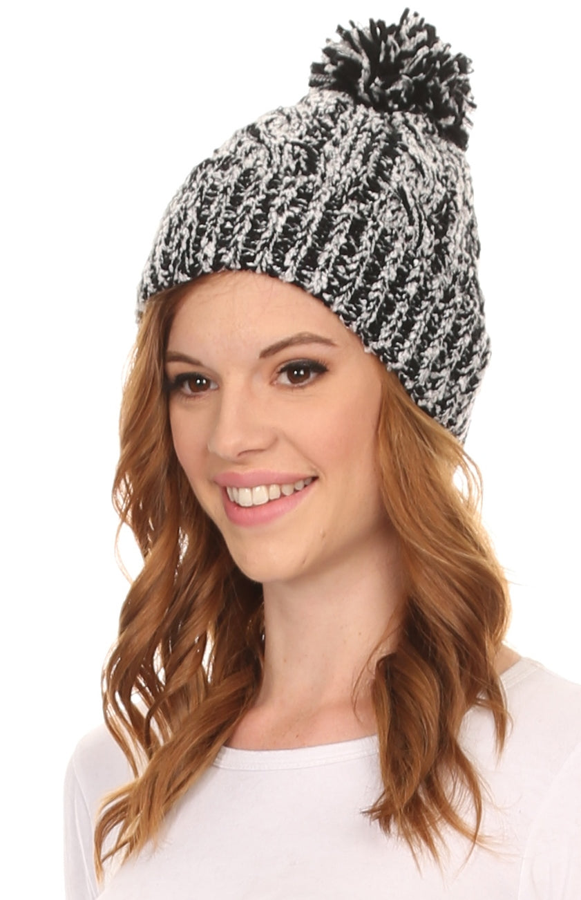 Black-and-white speckled textured knit beanie with fluffy pom pom, worn.