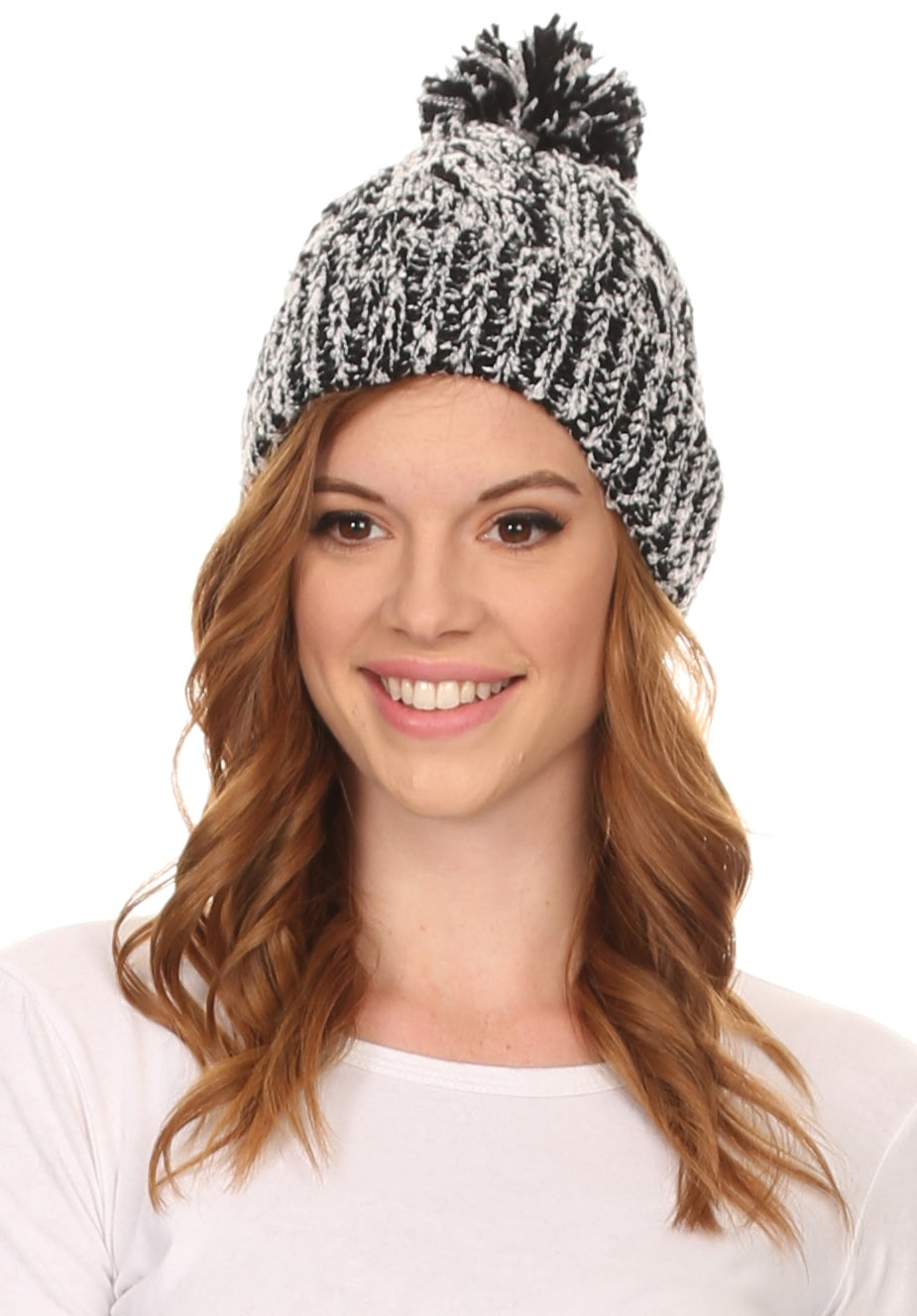 Black-and-white speckled knit beanie with large pom pom, worn on head.