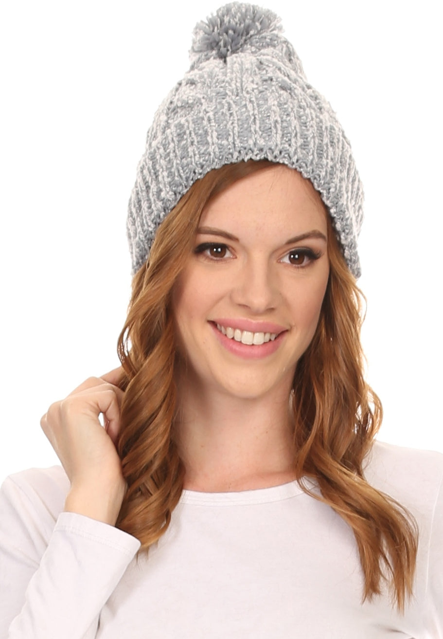 Light grey heather knit beanie with fluffy pom pom, worn with smile.