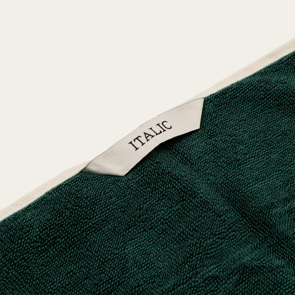 Green cotton towel with ecru label reading ITALIC and textured weave detail