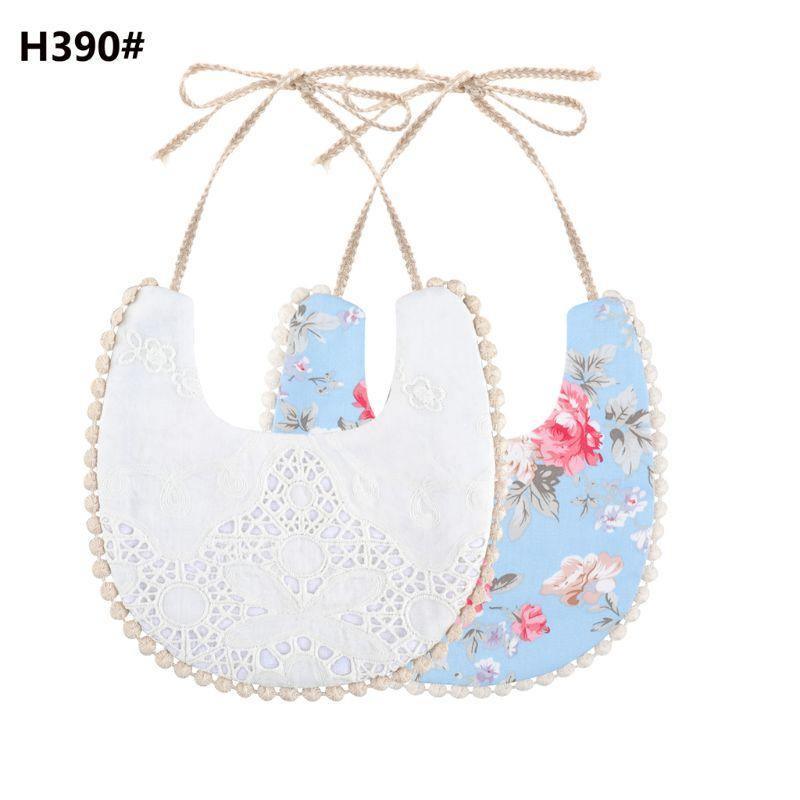 Double-sided cotton baby bib with tassel ties; white eyelet and blue floral print.