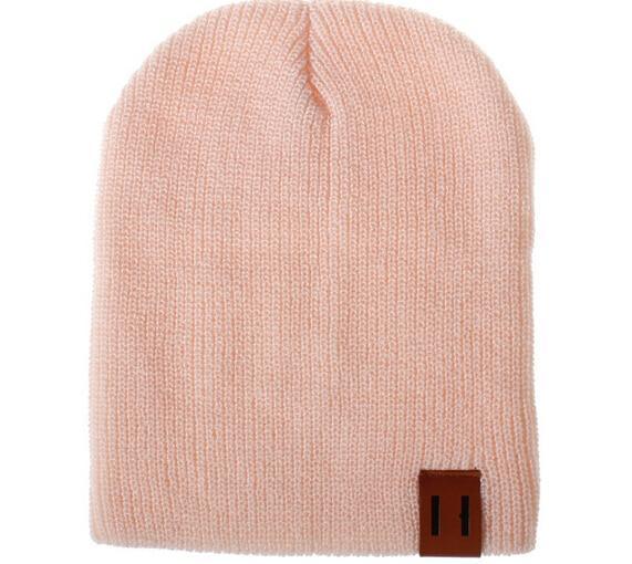 Light pink knit beanie hat with front logo patch