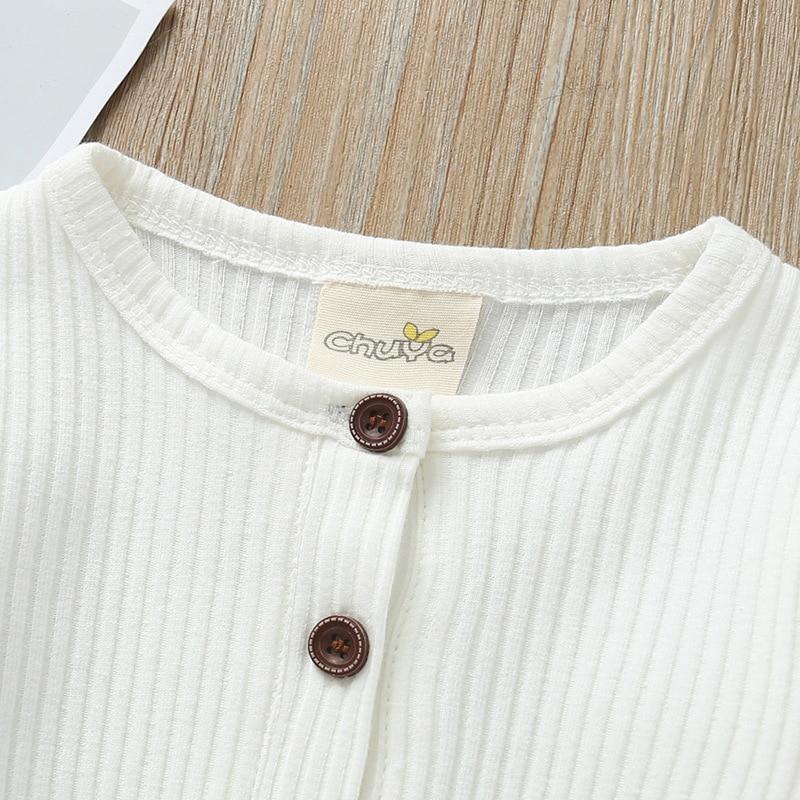 White newborn ribbed romper neckline with round brown buttons and snap placket
