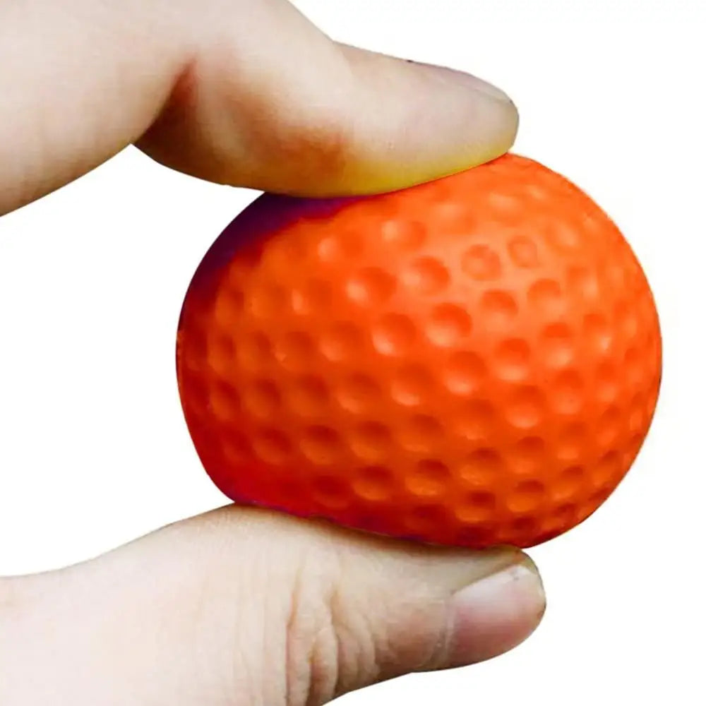 Orange foam golf practice ball with deep dimples, held in hand