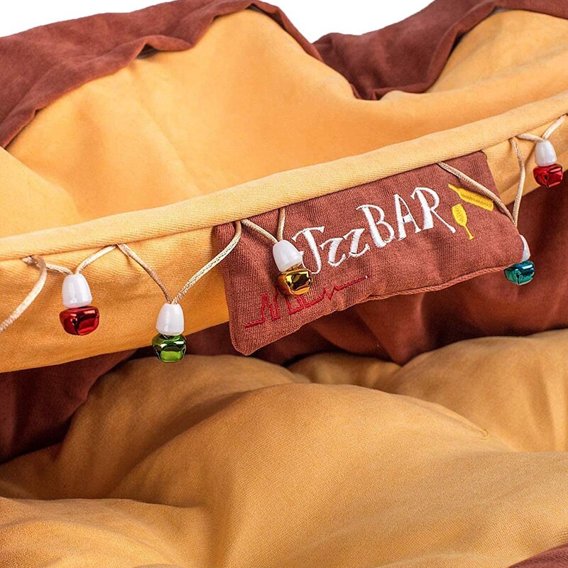 Cat tunnel bed with embroidered panel and dangling bead toys along the rim