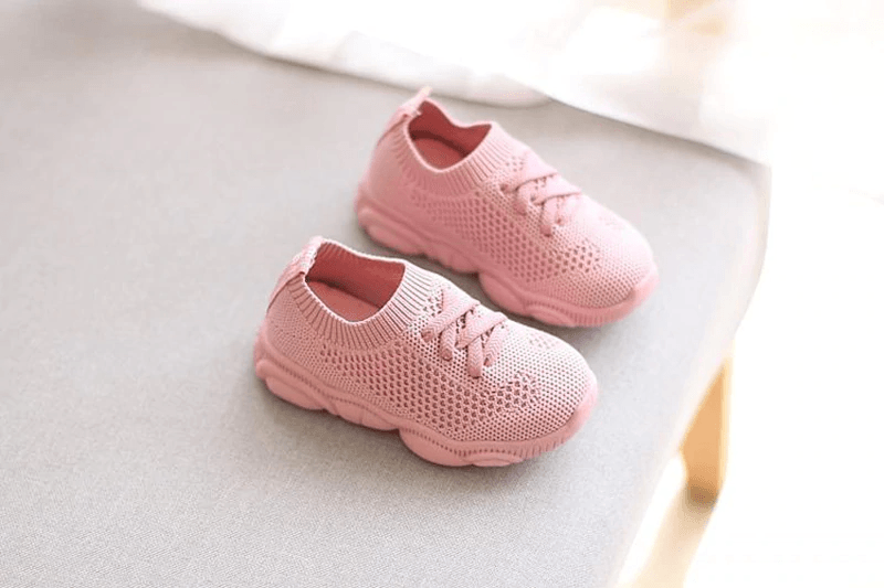 Pink knit baby sneakers with lace-up closure and thick cushioned soles
