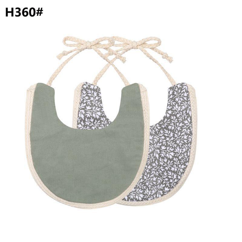Double-sided cotton baby bib with tassel ties; gray solid and navy floral print.