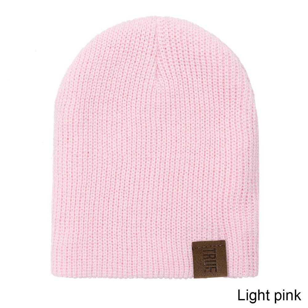 Light pink knit baby beanie with small logo patch