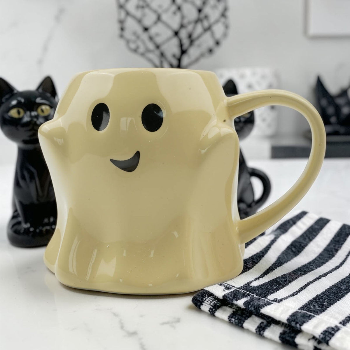 Yellow ghost-shaped ceramic mug with smiling face and right-side handle