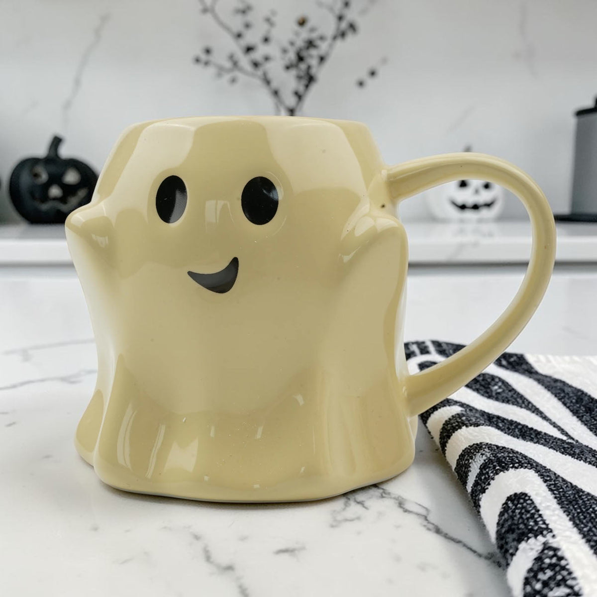 Yellow ghost-shaped ceramic mug with smiling face and curved side handle