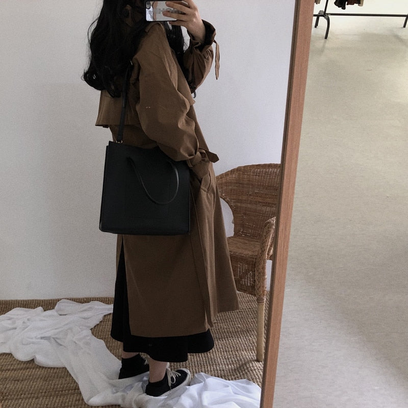 Black double-breasted long overcoat with belt and button front, long sleeves