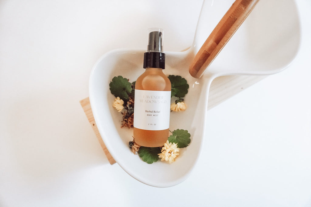 Lavender Meadows Co herbal relief body mist bottle in a white dish with dried flowers