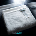 Folded white organic bath mat with Bathmod tag