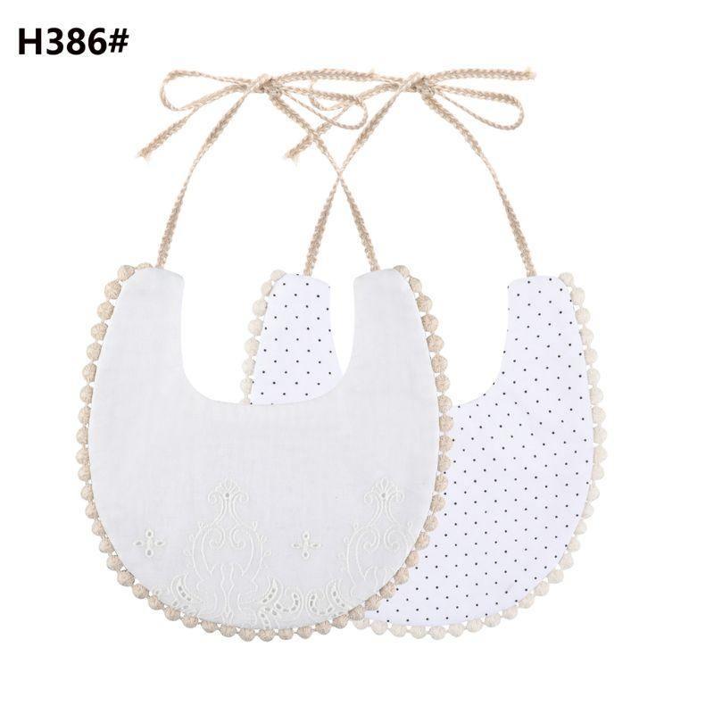 Infant double-sided bib with tassel ties, white eyelet front and dotted purple reverse